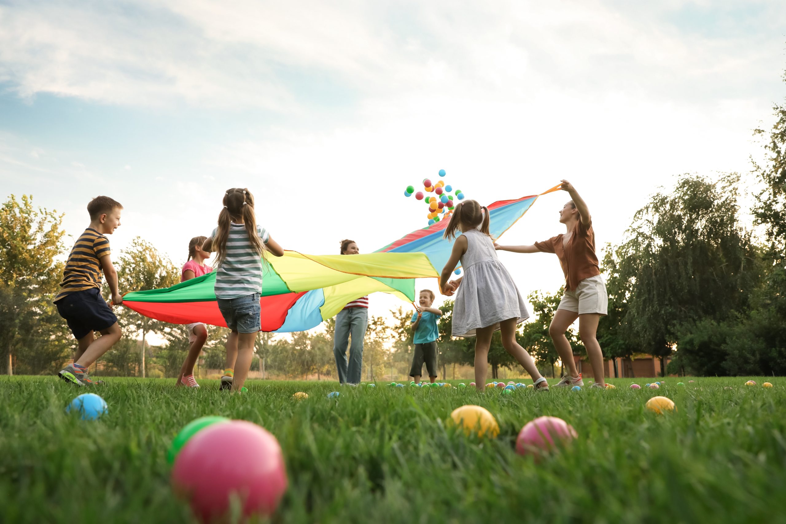 Children playing in the local park on grass